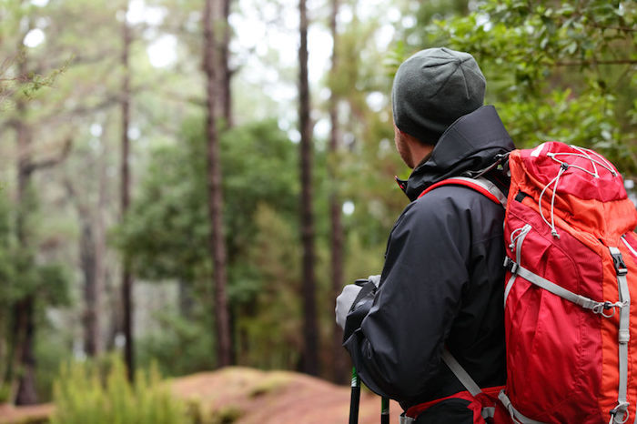 Hiker wearing hiking backpack and hardshell jacket Hiker with Backpack